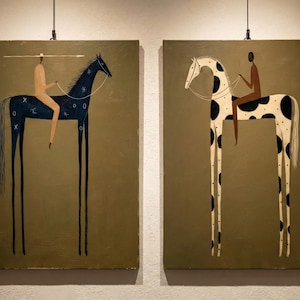 May include: Two framed paintings depict stylized horses with elongated legs, each ridden by a figure. One horse is dark blue with white markings, the other is white with black spots. The background is a muted olive green.