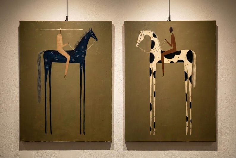 May include: Two framed paintings depict stylized horses with elongated legs, each ridden by a figure. One horse is dark blue with white markings, the other is white with black spots. The background is a muted olive green.