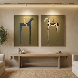 May include: Two framed art prints depict stylized figures riding horses with elongated legs. One horse is navy blue with white dots, the other is white with black spots. Both are set against an olive green background.