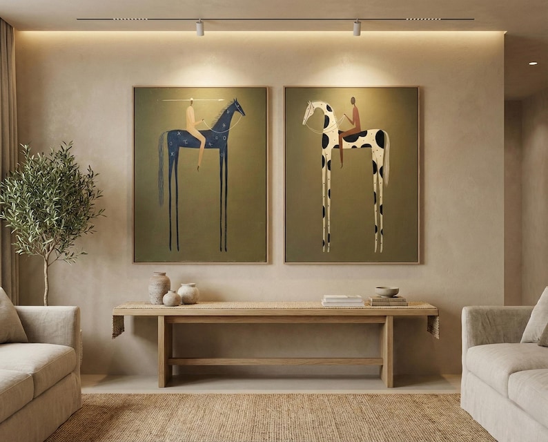 May include: Two framed art prints depict stylized figures riding horses with elongated legs. One horse is navy blue with white dots, the other is white with black spots. Both are set against an olive green background.