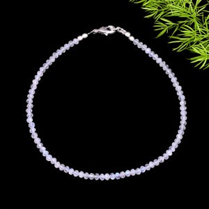 May include: Delicate necklace featuring small, round, iridescent beads. The necklace has a silver clasp and is displayed against a black background. The beads appear to be moonstone, and the necklace is a fine piece of jewelry.