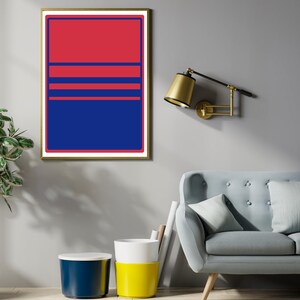May include: A framed abstract art print with a gold border. The artwork features a bold design with a red upper section, blue lower section, and three horizontal blue lines. The print is displayed on a grey wall.