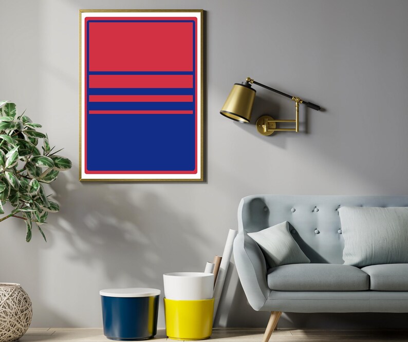 May include: A framed abstract art print with a gold border. The artwork features a bold design with a red upper section, blue lower section, and three horizontal blue lines. The print is displayed on a grey wall.