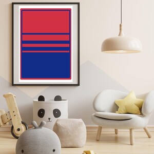 May include: A framed art print with a striking red and blue geometric design. The artwork features a rectangular shape divided into sections with horizontal lines. The print is displayed in a room with children's decor, including a wooden toy and a panda-themed storage bin.