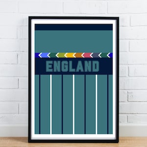 May include: Framed art print with a teal and navy blue design, displaying the word "ENGLAND". The artwork features vertical stripes and a horizontal band of colourful arrows. The frame is black.