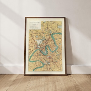 Könnte beinhalten: Gerahmte Vintage-Karte von Brisbane, Australien, in einem dunklen Holzrahmen. Die Karte zeigt einen detaillierten Stadtplan mit Straßen, Wasserwegen und Text. Die Karte ist hauptsächlich gelb und beige mit blauen und roten Akzenten.