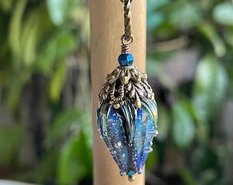 Collar con colgante de flor de cristal azul: cadena de bronce y gota de cristal rosa.