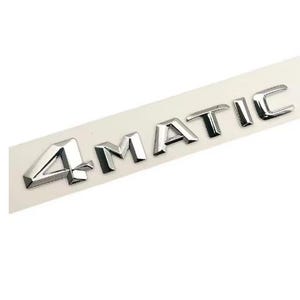 May include: A chrome "4MATIC" emblem, possibly for a car, is presented on a white rectangular backing. The letters are in a bold, sans-serif font, reflecting light and creating a metallic sheen. The emblem is designed for automotive applications.
