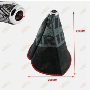 Puede incluir: Una funda de palanca de cambios de coche negra y gris con ribete rojo, que mide 26 cm de ancho y 22 cm de alto. La funda tiene un patrón de malla con la palabra "R" visible. Un anillo de metal cromado está en la parte superior y la abertura es de 17 mm.