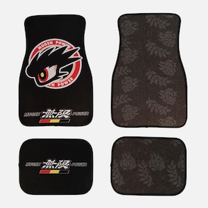 Könnte beinhalten: Set aus vier schwarzen Auto-Fußmatten. Zwei Matten zeigen den Text "MUGEN POWER" mit einem stilisierten Augendesign. Die anderen beiden Matten haben ein graues Blumenmuster.