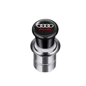 May include: A black car cigarette lighter with the Audi logo in white and red. The lighter has a chrome-colored base and a black top with the Audi emblem. The design is sleek and modern.