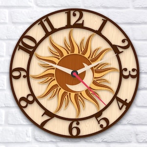 Könnte beinhalten: Eine Wanduhr aus Holz mit einem Sonnen- und Monddesign. Das Zifferblatt hat einen hellen Holzgrund mit dunkelbraunen Ziffern und einer Sonne und einem Mond in der Mitte. Die Zeiger sind weiß mit einem roten Sekundenzeiger.