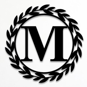 May include: A black metal wall sign featuring a large capital letter M centred within a circular frame decorated with a leaf wreath pattern. The text Custom Order is visible in the upper left corner of the image.