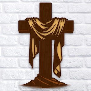 Puede incluir: Una cruz de madera con un diseño de tela drapeada. La cruz es marrón con una tela de color beige claro drapeada sobre ella. La imagen incluye el texto "3 LAYERS SVG PNG DXF" en la esquina superior izquierda.