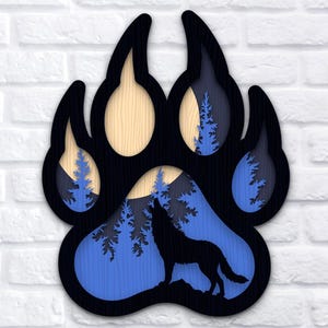 Puede incluir: Un diseño de huella de pata de madera en capas con un lobo aullando a la luna, sobre un fondo de escena de bosque azul y negro. El diseño incluye el texto "4 LAYERS SVG PNG DXF".