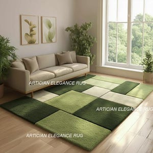 Könnte beinhalten: Moderner Teppich mit einem geometrischen Patchwork-Design in verschiedenen Grün- und Cremetönen. Der Teppich befindet sich in einem Wohnzimmer mit einem beigen Sofa. Der Text "ARTICIAN ELEGANCE RUG" ist auf dem Teppich aufgedruckt.