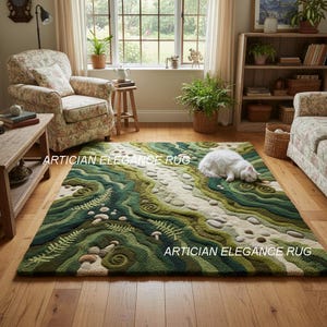 Könnte beinhalten: Ein rechteckiger Teppich mit einem von der Natur inspirierten Design. Der Teppich weist ein Muster aus Grün und Beige auf, das einer Landschaft mit fließenden Linien und strukturierten Details ähnelt. Eine weiße Katze liegt auf dem Teppich. Der Text "ARTICIAN ELEGANCE RUG" ist sichtbar.