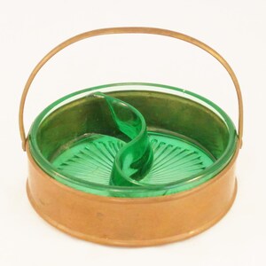 May include: A vintage divided serving dish with a green glass interior and a copper-toned metal exterior. The dish has a handle and a decorative green glass divider. The glass has a textured, fan-like pattern.