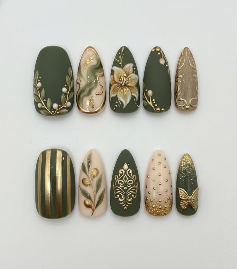 May include: A set of ten artificial nails in various shapes and designs. The nails feature olive green, gold, and beige colors with floral, striped, and abstract patterns. Some nails have 3D embellishments.