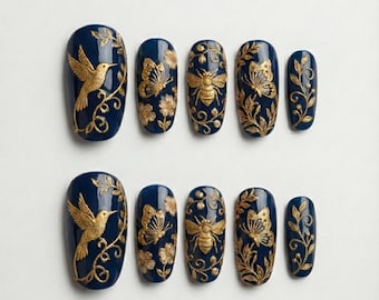 May include: Set of ten navy blue press-on nails with gold embellishments. Designs include a hummingbird, butterflies, bees, and floral patterns. The nails are oval-shaped and have a glossy finish.