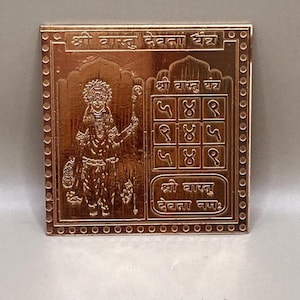 Könnte beinhalten: Quadratische, kupferfarbene Metallplakette mit aufwendigen Gravuren. Die Plakette zeigt eine detaillierte Darstellung einer Gottheit und mehrere Textzeilen in einer fremden Schrift. Der Rand ist mit kleinen, gleichmäßig verteilten kreisförmigen Details verziert.