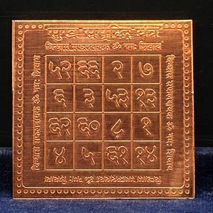 May include: A square copper-colored metal plate featuring an engraved grid of sixteen squares filled with Devanagari numerals. The border is decorated with a dotted pattern, and Sanskrit text is inscribed along the top and side edges.