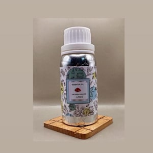 May include: A silver-coloured bottle with a white screw cap containing litchi essential oil. The label features a botanical line drawing pattern with a central rectangular box displaying the text ESSENTIAL OIL, 100% PURE & UNDILUTED, LITCHI.