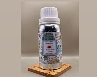 May include: A silver-colored bottle with a white screw cap containing litchi essential oil. The label features a botanical line drawing pattern with a central rectangular box displaying the text ESSENTIAL OIL, 100% PURE & UNDILUTED, LITCHI.