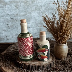 Decorative ceramic bottles, hand-painted with toucan birds and palm leaves, eco-friendly kitchen gift idea.
Unique handmade pottery cruet set for olive oil, vinegar, or balsamic, rustic boho kitchenware.
Mediterranean style ceramic bottles with vibrant designs, perfect for gourmet cooking lovers and housewarming gifts.