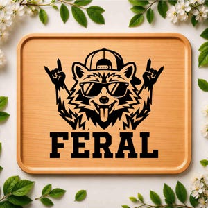 May include: A wooden tray with a black graphic of a raccoon wearing sunglasses and a backwards baseball cap, giving a rock and roll hand gesture. The word "FERAL" is printed in bold, black letters below the raccoon.