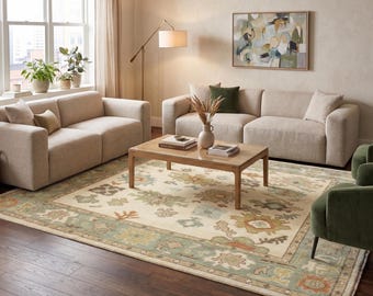 May include: A living room scene featuring two beige sofas, two green armchairs, and a wooden coffee table on a patterned rug. A painting hangs on the wall, and a floor lamp provides additional lighting.