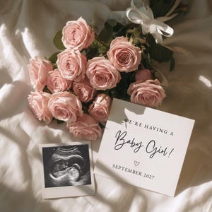 May include: A bouquet of light pink roses tied with a white ribbon, a square card with the text "WE'RE HAVING A Baby Girl!" and "SEPTEMBER 2027" with a small heart, and a square ultrasound scan print showing a developing fetus.