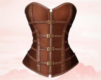 May include: A brown corset with a steampunk aesthetic. The bodice features a front zipper, multiple buckle closures, and leather straps. The corset is made of brown leather and suede-like material.
