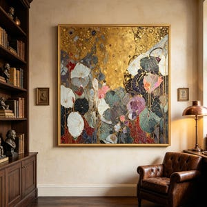 Puede incluir: Gran impresión artística floral cuadrada con marco dorado. La obra presenta un fondo dorado con un diseño floral en blanco, rosa, morado y verde. La pintura cuelga de una pared beige en una habitación con una estantería y un sillón de cuero.
