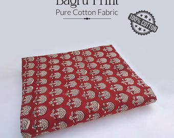 May include: A folded piece of red Bagru Print pure cotton fabric. The fabric is patterned with a repeating off-white floral design. The text "Bagru Print" and "Pure Cotton Fabric" are displayed above the fabric.