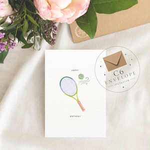 May include: A white greeting card featuring a tennis racket with a green frame and pink handle, a green tennis ball, and the text HAPPY BIRTHDAY. A circular graphic indicates a C6 envelope is included with the card.