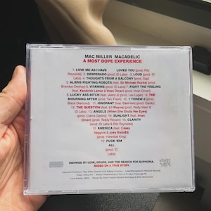 Pu&ograve; includere: Una custodia trasparente per CD con l'album "Macadelic: A Most Dope Experience" di Mac Miller. La tracklist &egrave; visibile, con canzoni come "Love Me As I Have Loved You" e "The Question". Il tema dell'album &egrave; ispirato all'amore, alla droga e alla ricerca dell'euforia.