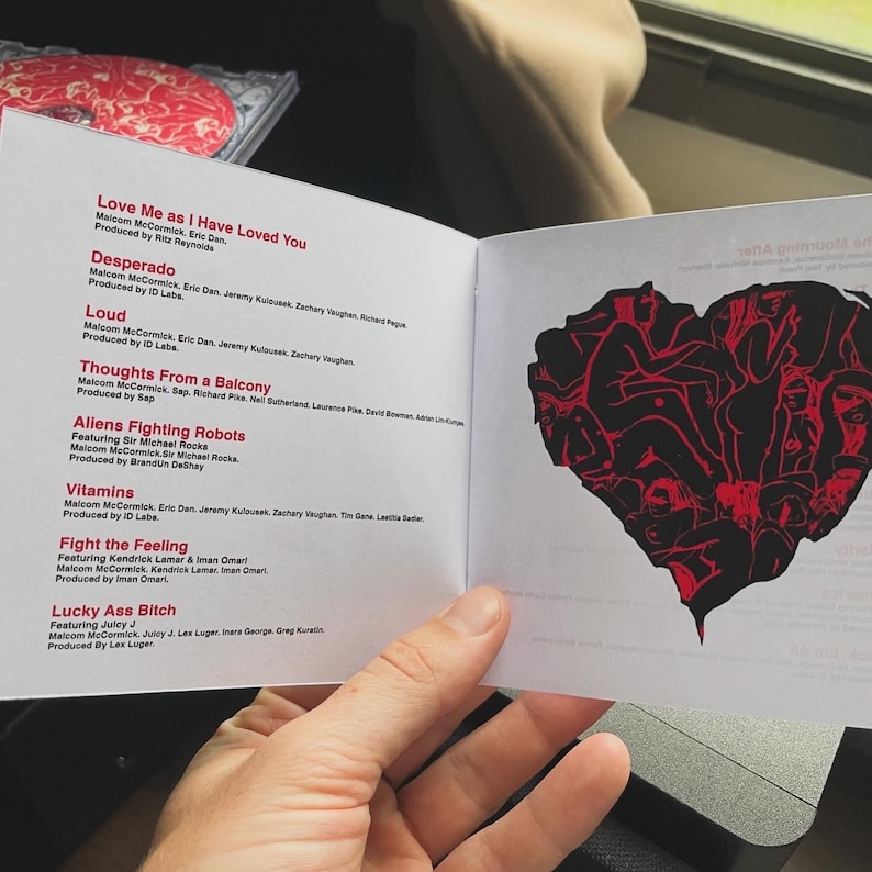 Pu&ograve; includere: Un libretto di CD con titoli di canzoni e crediti. Il libretto aperto mostra una grafica a forma di cuore rosso e nero sulla pagina di destra. La pagina di sinistra elenca titoli di canzoni come "Love Me as I Have Loved You" e "Desperado".