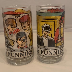May include: Two clear glass tumblers with cartoon illustrations. One features comic characters and the text "FUNNIES" and names "LARRY", "BASIL", and "EX". The other glass has "FUNNIES" and names "ASP" and "ALWORE".