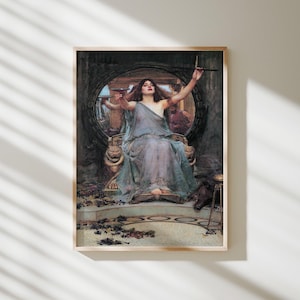 May include: A framed art print depicting a woman in a flowing, translucent blue-grey gown seated on a throne with lion-headed armrests. She holds a shallow bowl aloft in one hand and a wand in the other, with a dark boar resting near her feet.
