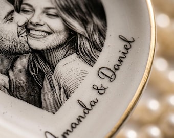 May include: Heart-shaped ceramic dish with a black and white photo of a couple kissing. The dish has a gold rim and the names "Amanda & Daniel" in script.