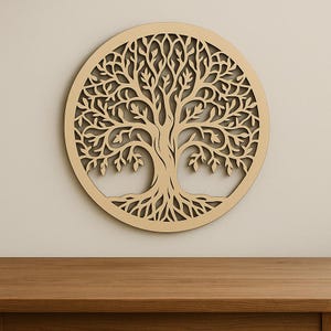 May include: A round, wooden wall art piece featuring a detailed tree of life design. The tree's branches and roots are intricately cut out within a circular frame. The artwork is a light brown color and is mounted on a neutral-toned wall.