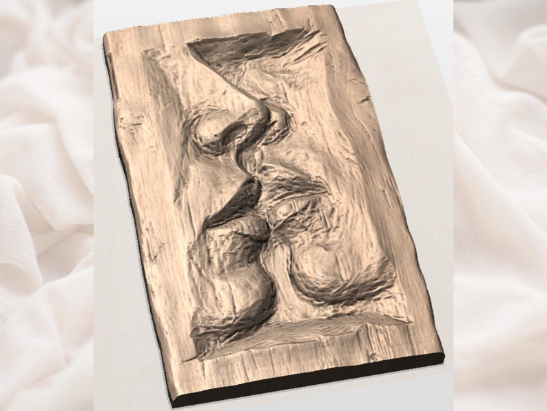 May include: A wooden relief sculpture depicting two faces in profile, seemingly in an embrace or kiss. The artwork is carved into a rectangular wooden block, showcasing detailed textures and shadows. The piece has a warm, natural wood tone.