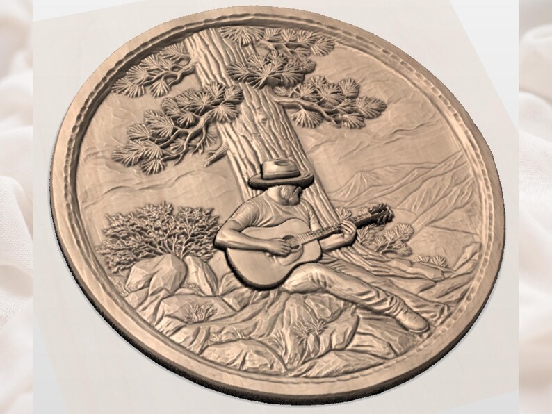 May include: A bronze-colored, circular relief sculpture depicting a person playing a guitar under a tree. The detailed artwork includes a hat, clothing, and a mountainous background, all within a decorative border.