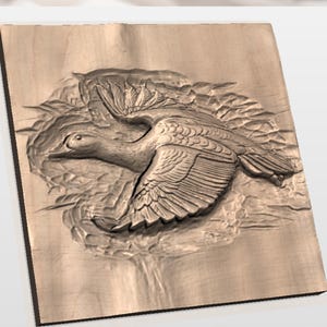 May include: A wooden relief carving of a duck in flight. The duck is depicted with outstretched wings, detailed feathers, and a textured surface. The carving is set against a background of stylized water and foliage, all within a rectangular frame.