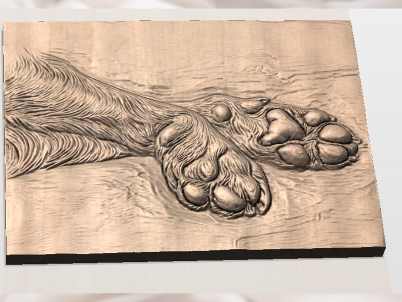 May include: A detailed wooden carving of a dog's paw and leg. The carving showcases the texture of the fur and the pads of the paw. The artwork is displayed on a rectangular wooden surface, with the grain of the wood visible.