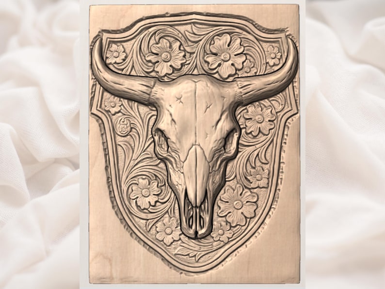 May include: A wooden carving of a bull skull with long horns, centered on a decorative shield. The shield is adorned with floral patterns and scrollwork. The carving is in a natural wood tone.