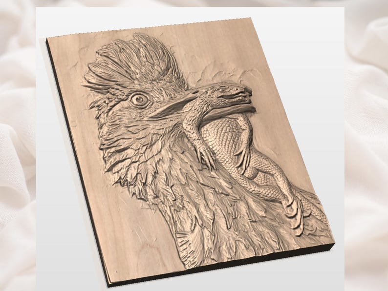 Puede incluir: Un relieve de madera tallada representa un ave rapaz con un lagarto en el pico. La obra de arte est&aacute; tallada en madera de color claro, mostrando texturas detalladas de plumas y escamas. El ojo del ave est&aacute; abierto y el lagarto est&aacute; en su boca.