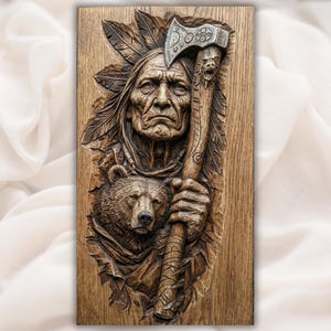 May include: A detailed wood carving of a Native American chief holding an axe, with a bear's head at the bottom. The carving is in shades of brown and tan, with intricate details in the feathers and the axe head.