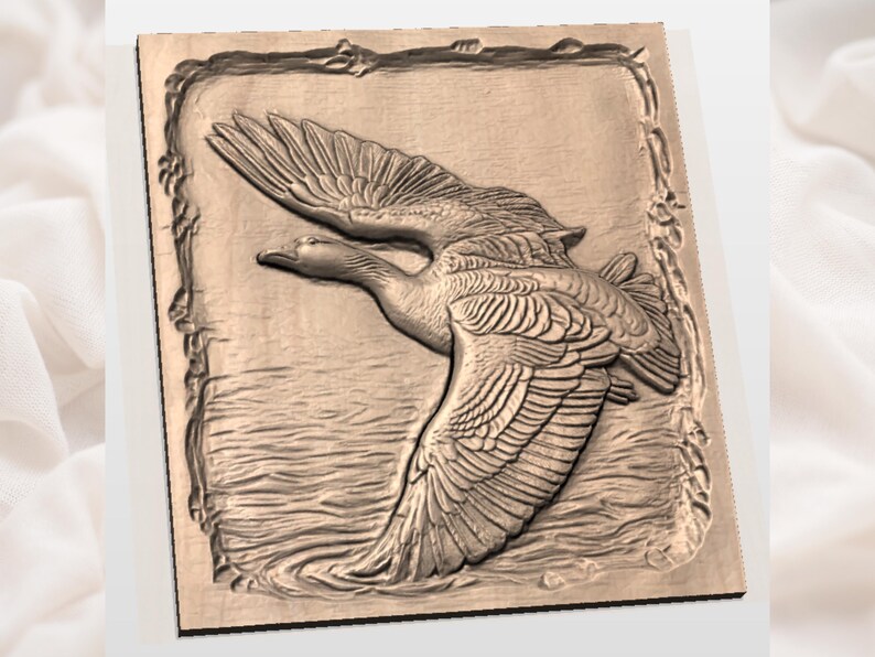 May include: A wooden relief carving of a goose in flight over water. The artwork is framed with a decorative border. The goose is depicted with detailed feathers and outstretched wings, creating a sense of motion.